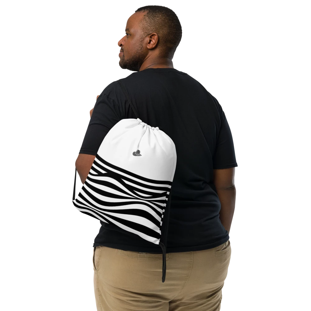 A man shown from the back wearing a black t-shirt and khaki pants, carrying a white drawstring bag with a black zebra-stripe pattern on his shoulder against a white background.
